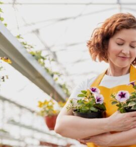 Female gardener embracing potted flowers